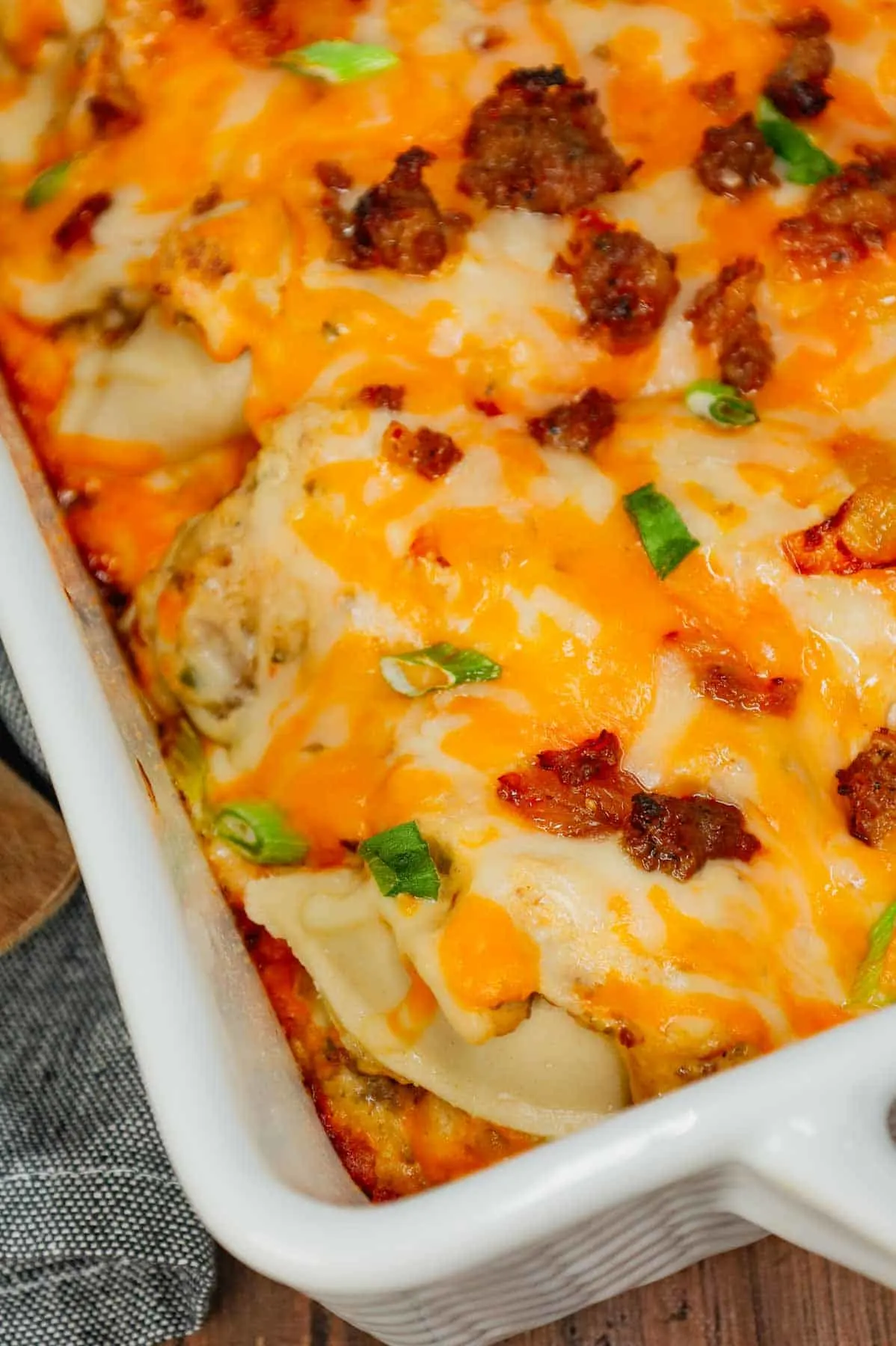 Pierogi Casserole is a hearty dinner recipe loaded with crumbled Italian sausage, onions, three cheese pierogies, cream cheese, Alfredo sauce, shredded mozzarella and cheddar cheese.