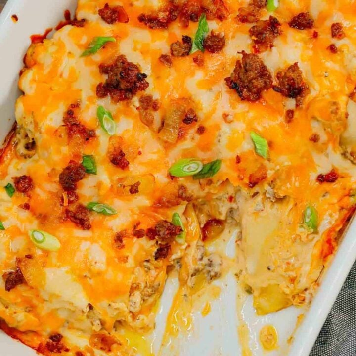 Pierogi Casserole is a hearty dinner recipe loaded with crumbled Italian sausage, onions, three cheese pierogies, cream cheese, Alfredo sauce, shredded mozzarella and cheddar cheese.