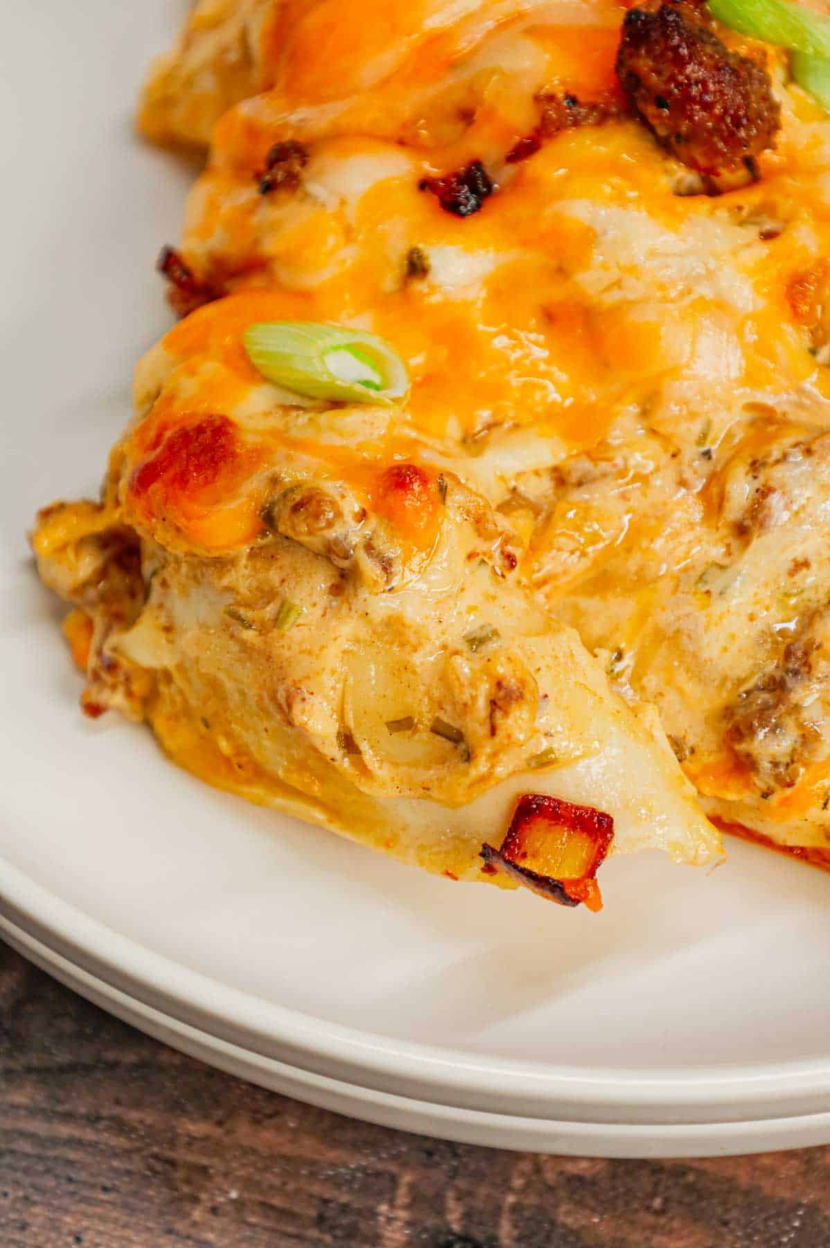 Pierogi Casserole is a hearty dinner recipe loaded with crumbled Italian sausage, onions, three cheese pierogies, cream cheese, Alfredo sauce, shredded mozzarella and cheddar cheese.