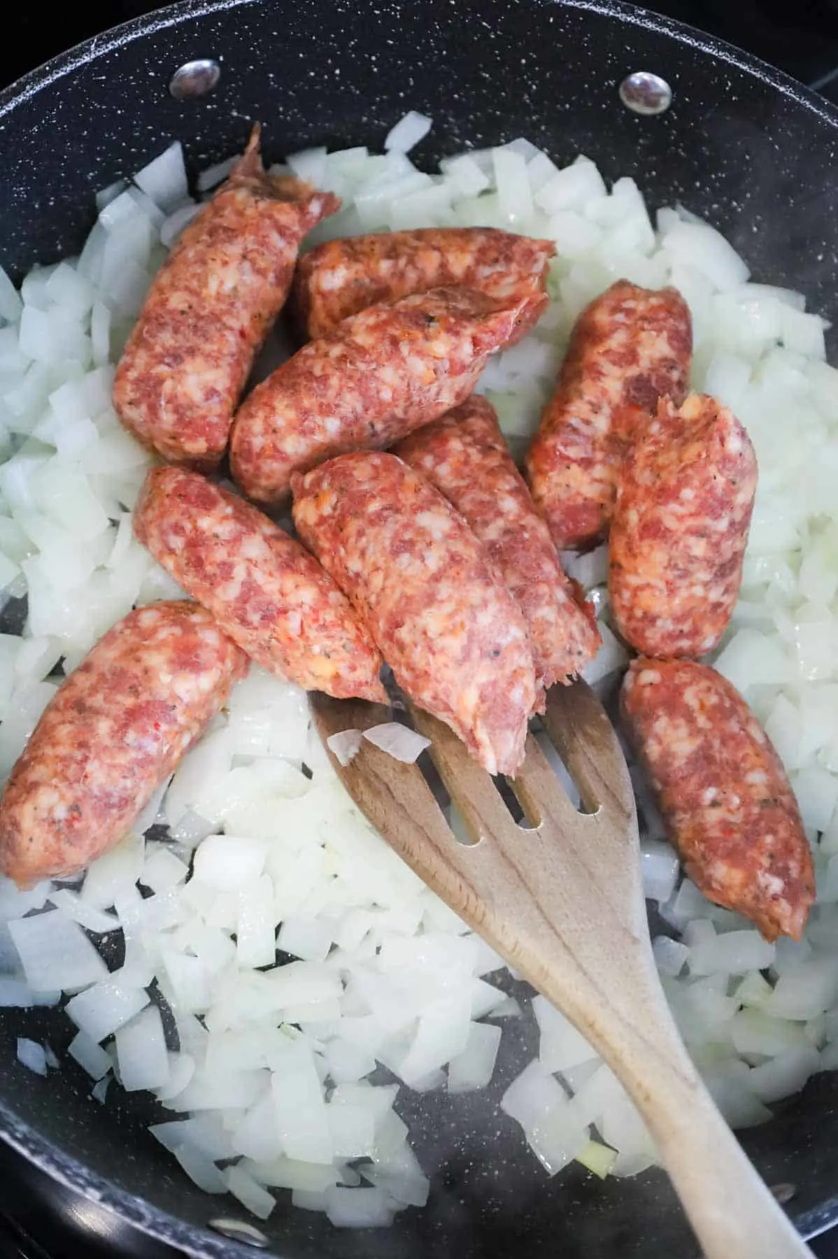 Italian sausage meat added to skillet with diced onions
