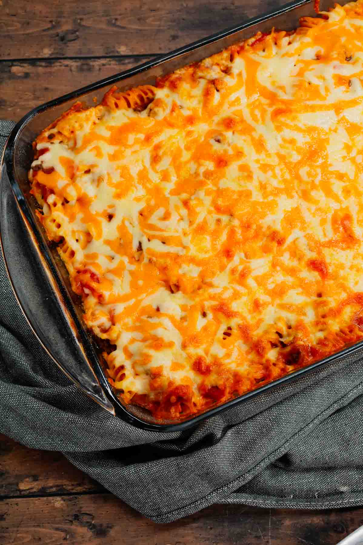 Cheeseburger Casserole is a hearty dish loaded with rotini pasta, ground beef, diced red onions, diced tomatoes, cheddar soup and shredded cheddar cheese.