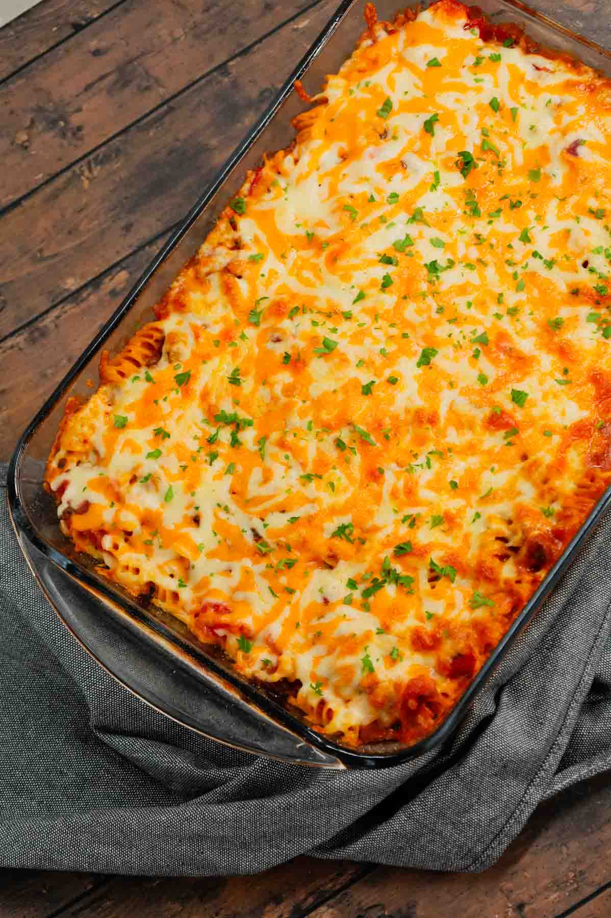 Cheeseburger Casserole is a hearty dish loaded with rotini pasta, ground beef, diced red onions, diced tomatoes, cheddar soup and shredded cheddar cheese.