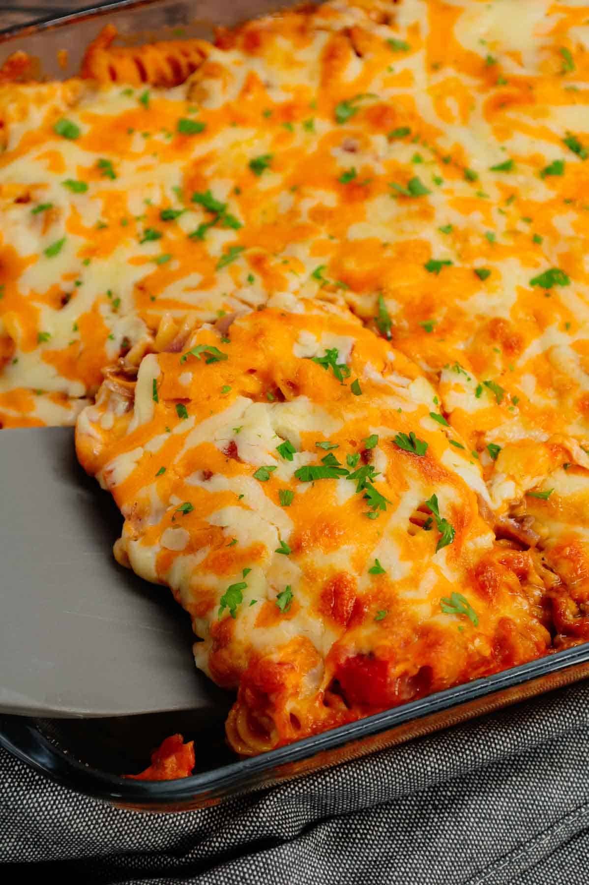 Cheeseburger Casserole is a hearty dish loaded with rotini pasta, ground beef, diced red onions, diced tomatoes, cheddar soup and shredded cheddar cheese.