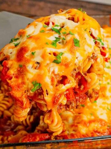 Cheeseburger Casserole is a hearty dish loaded with rotini pasta, ground beef, diced red onions, diced tomatoes, cheddar soup and shredded cheddar cheese.