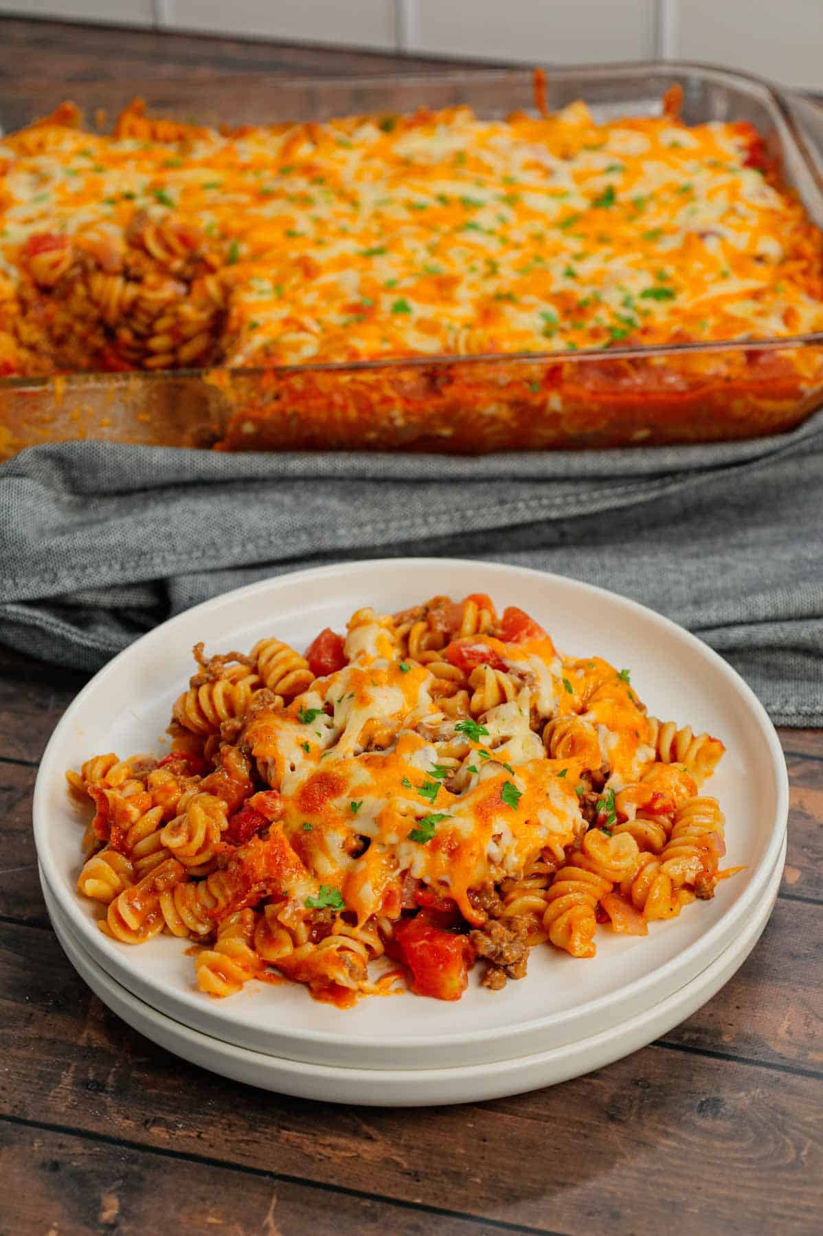 Cheeseburger Casserole is a hearty dish loaded with rotini pasta, ground beef, diced red onions, diced tomatoes, cheddar soup and shredded cheddar cheese.