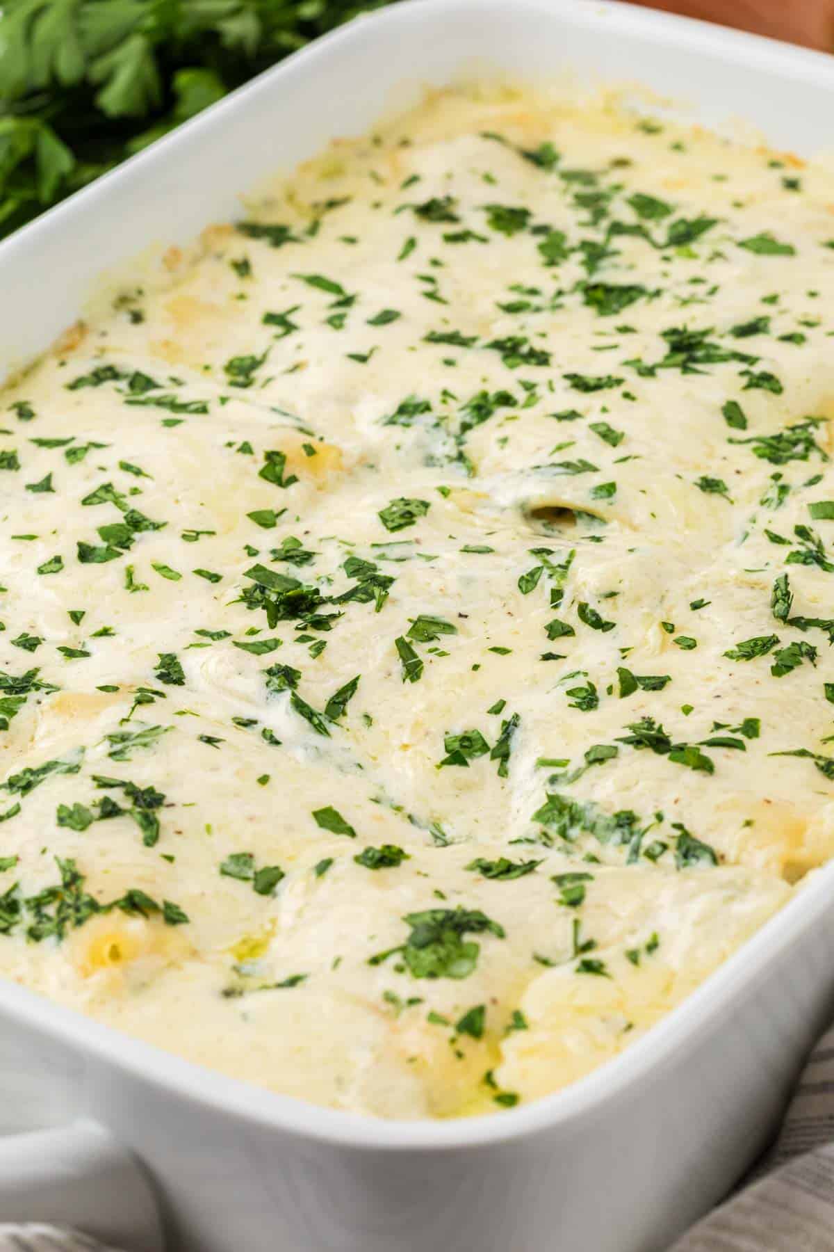 Chicken Alfredo Lasagna is a rich and delicious meal with layers of noodles, ricotta cheese, shredded chicken, mozzarella, sautéed spinach and mushrooms and a creamy Alfredo sauce.