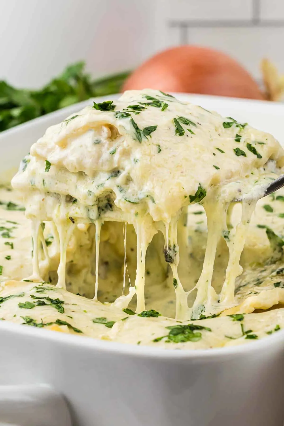 Chicken Alfredo Lasagna is a rich and delicious meal with layers of noodles, ricotta cheese, shredded chicken, mozzarella, sautéed spinach and mushrooms and a creamy Alfredo sauce.
