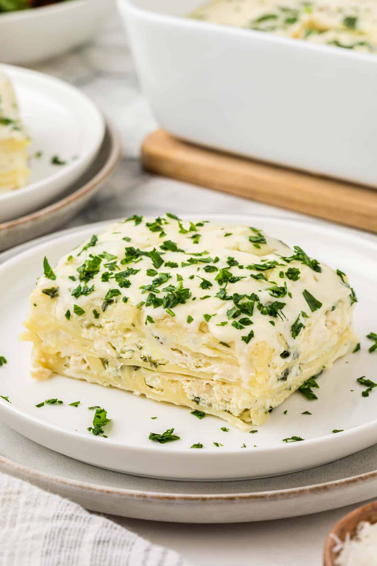 Chicken Alfredo Lasagna is a rich and delicious meal with layers of noodles, ricotta cheese, shredded chicken, mozzarella, sautéed spinach and mushrooms and a creamy Alfredo sauce.