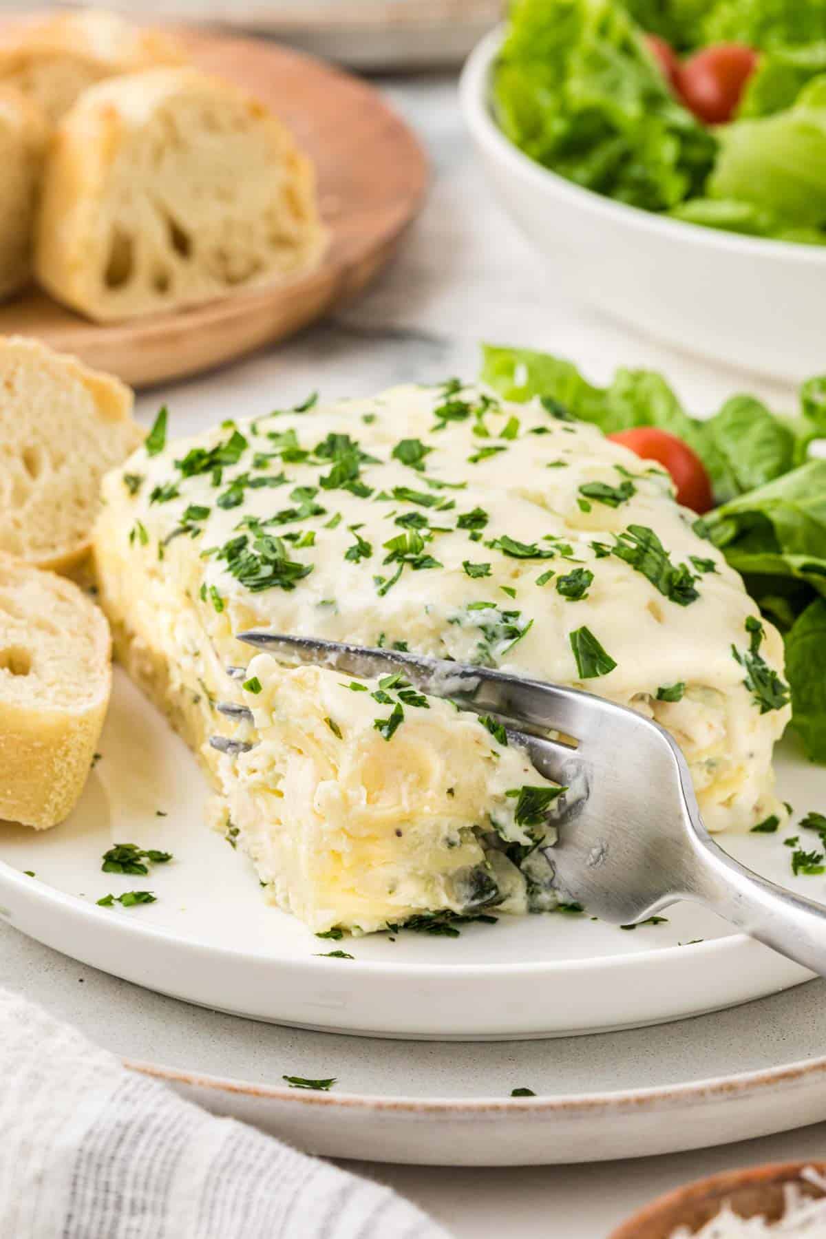 Chicken Alfredo Lasagna is a rich and delicious meal with layers of noodles, ricotta cheese, shredded chicken, mozzarella, sautéed spinach and mushrooms and a creamy Alfredo sauce.