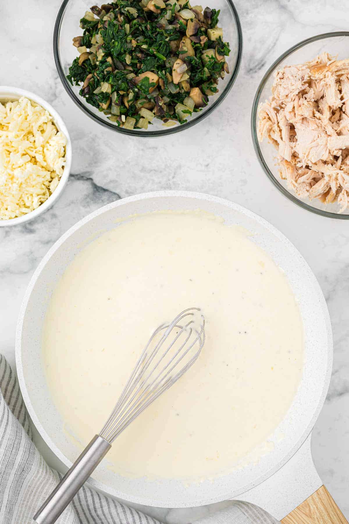 alfredo sauce cooking in a skillet