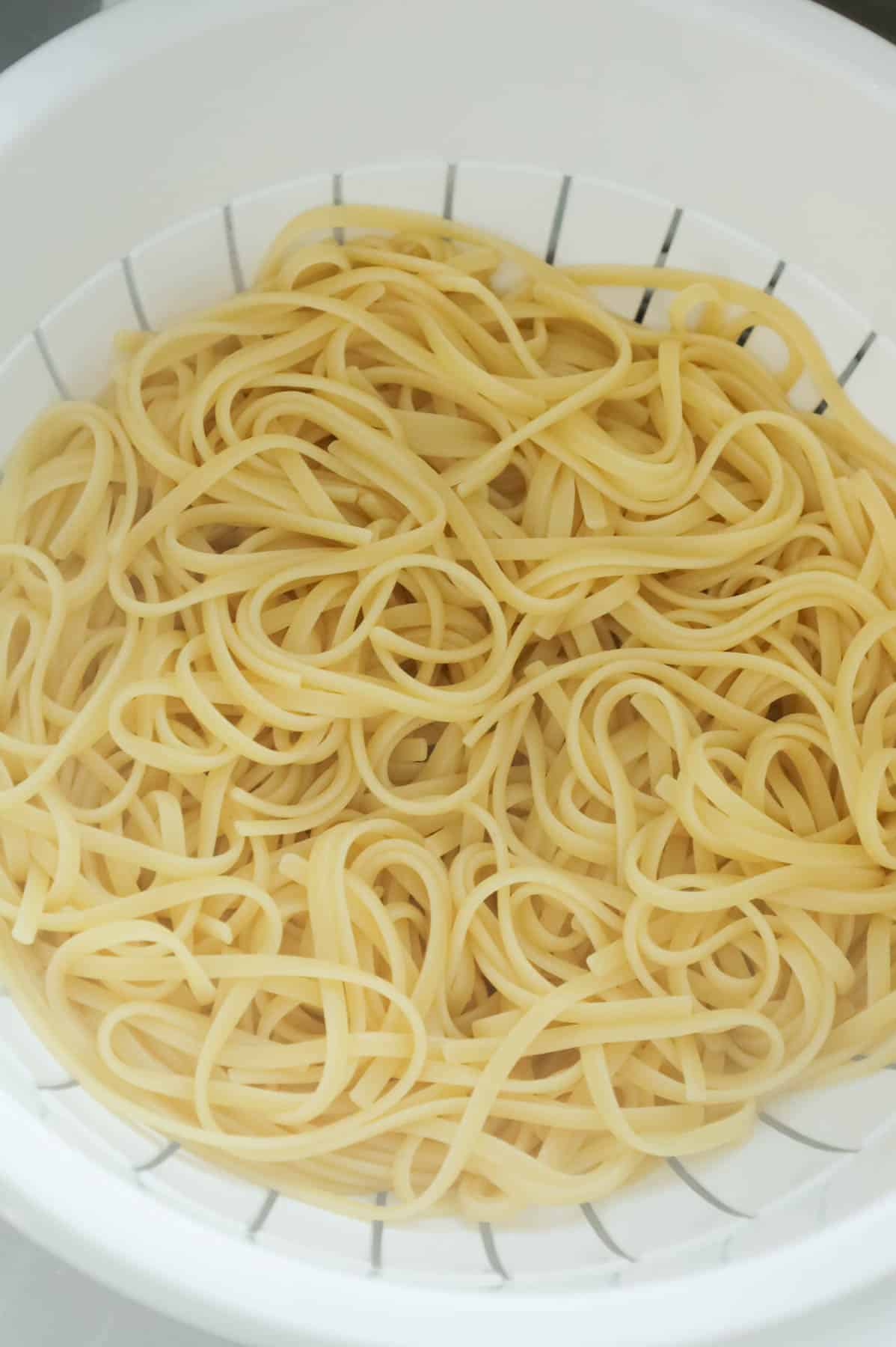 cooked linguine noodles in a colander