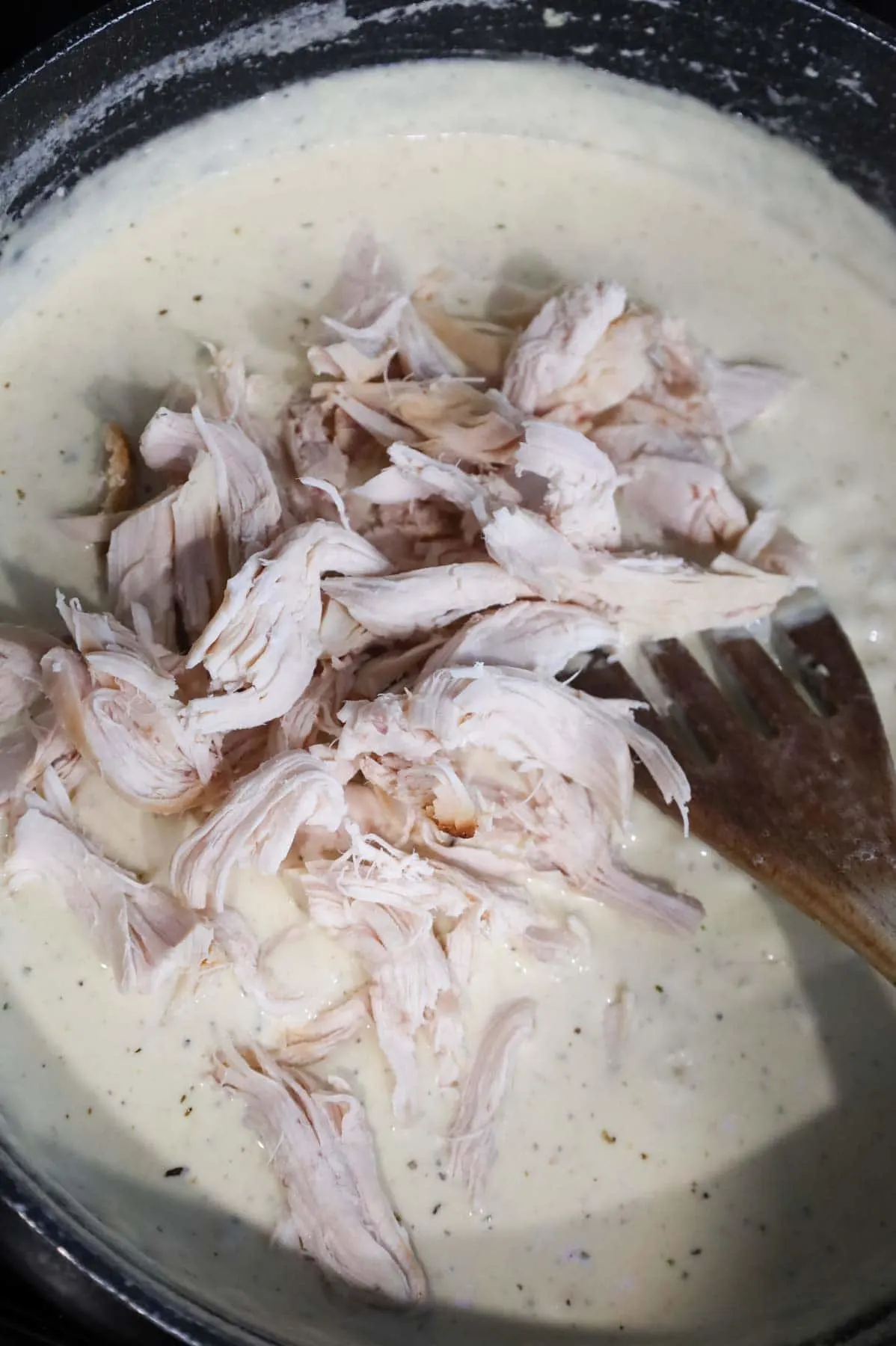shredded chicken added to skillet with cream cream sauce