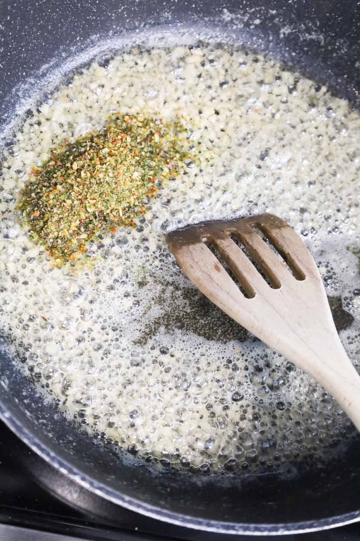 Italian seasoning added to skillet with melted butter and minced garlic