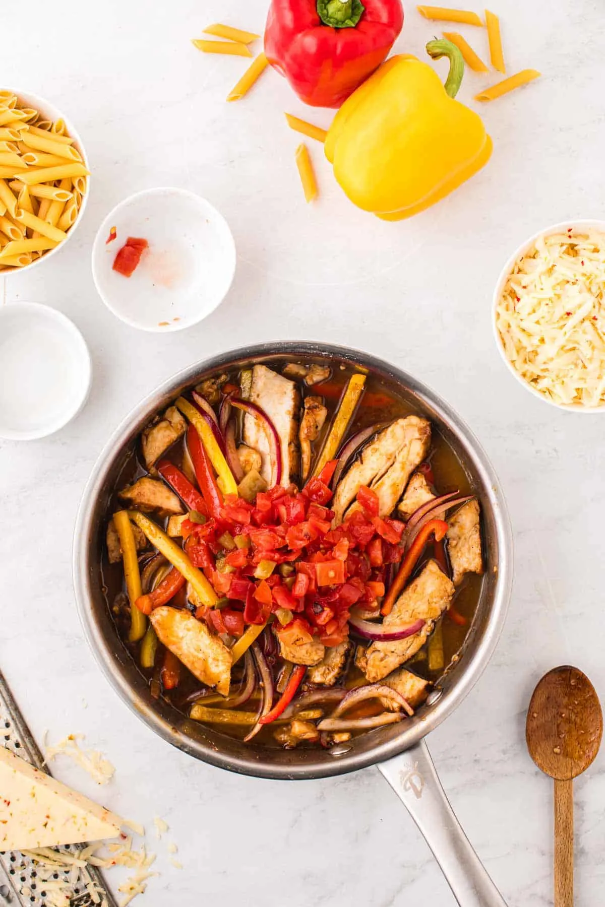 fire roasted tomatoes and chicken broth added to skillet with sliced chicken breasts and sliced bell peppers
