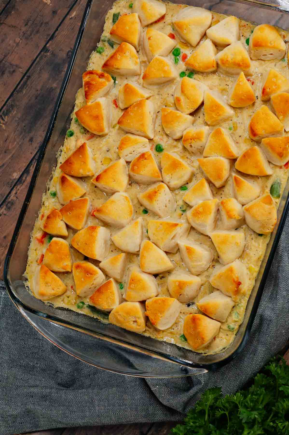 Chicken Pot Pie Casserole is a hearty casserole loaded with shredded rotisserie chicken, frozen mixed vegetables, cream of mushroom soup, cream of chicken soup, milk, grated parmesan cheese and chopped Pillsbury biscuits.