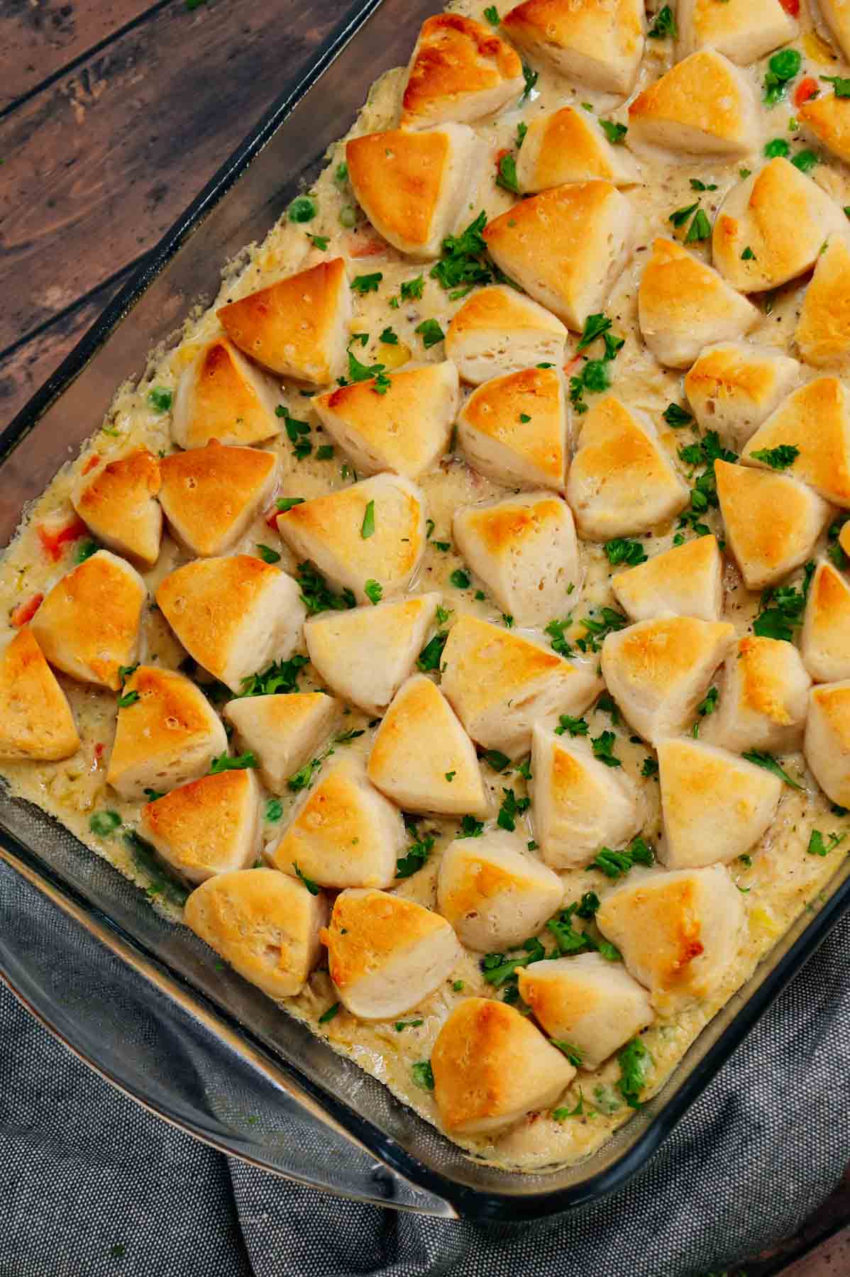 Chicken Pot Pie Casserole is a hearty casserole loaded with shredded rotisserie chicken, frozen mixed vegetables, cream of mushroom soup, cream of chicken soup, milk, grated parmesan cheese and chopped Pillsbury biscuits.