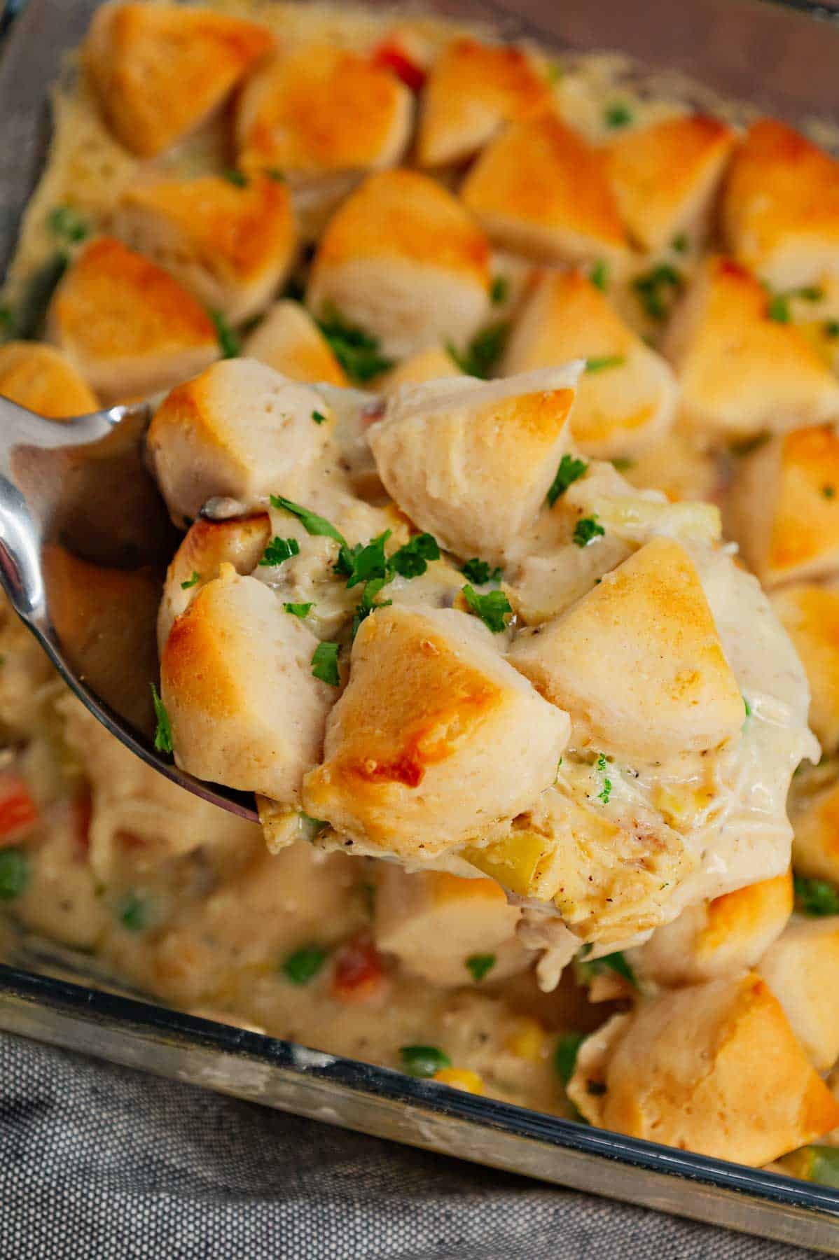 Chicken Pot Pie Casserole is a hearty casserole loaded with shredded rotisserie chicken, frozen mixed vegetables, cream of mushroom soup, cream of chicken soup, milk, grated parmesan cheese and chopped Pillsbury biscuits.