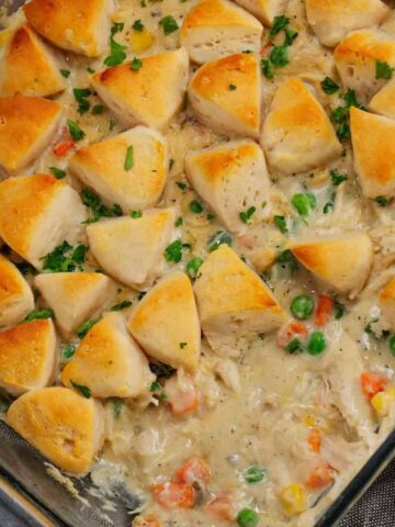 Chicken Pot Pie Casserole is a hearty casserole loaded with shredded rotisserie chicken, frozen mixed vegetables, cream of mushroom soup, cream of chicken soup, milk, grated parmesan cheese and chopped Pillsbury biscuits.