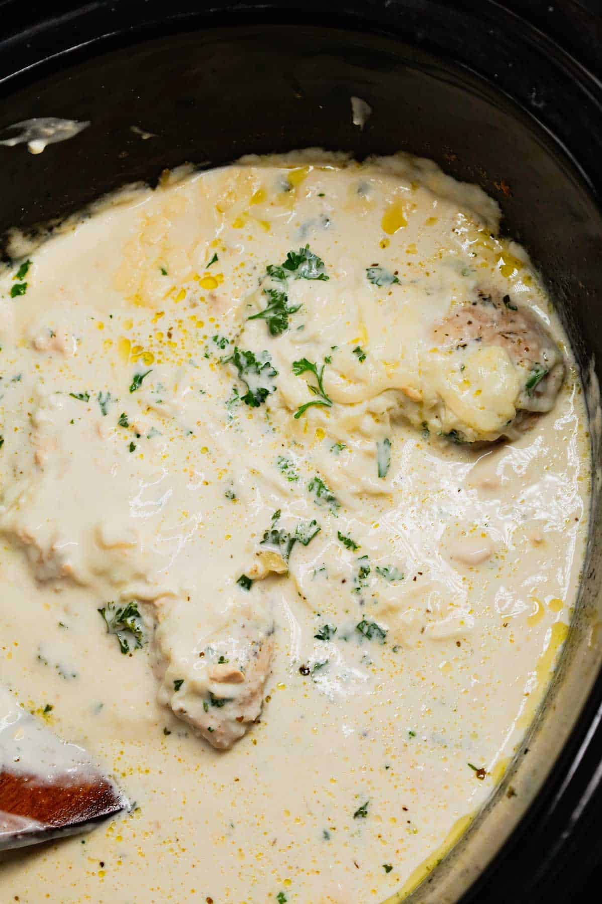 Crock Pot Parmesan Garlic Chicken is a rich and delicious slow cooker dish made with boneless, skinless chicken breasts in a creamy sauce loaded with minced garlic, parmesan cheese, Italian seasoning, fresh chopped parsley, cream cheese and mozzarella cheese.