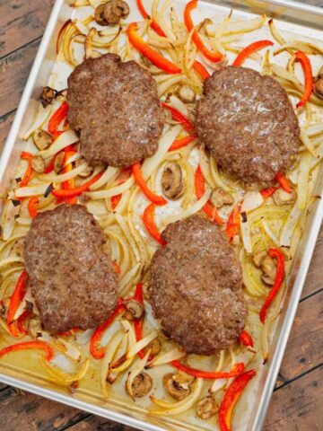 Oven Baked Hamburger Steaks are an easy sheet pan dinner recipe with seasoned ground beef patties cooked along with sliced onions, red bell peppers and mushrooms.