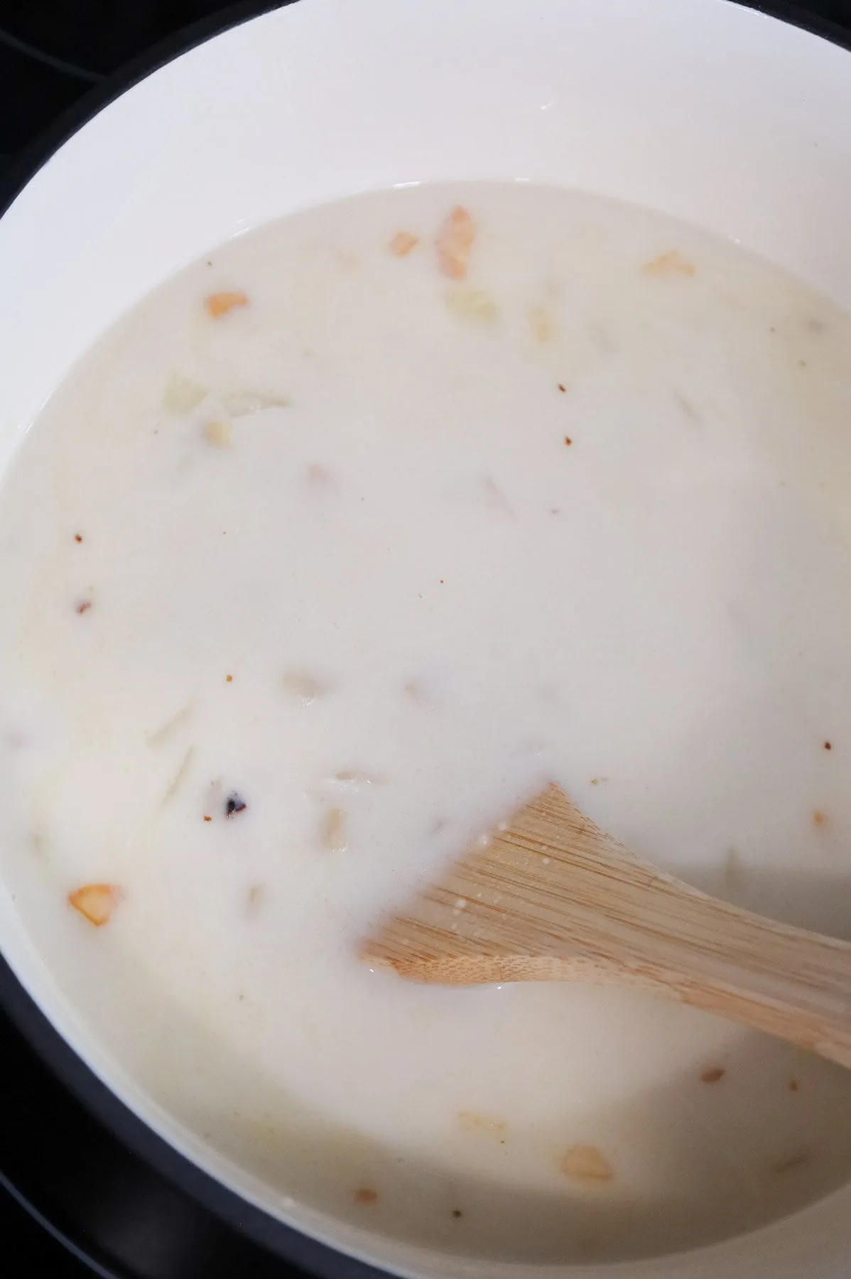 stirring milk into hash brown soup