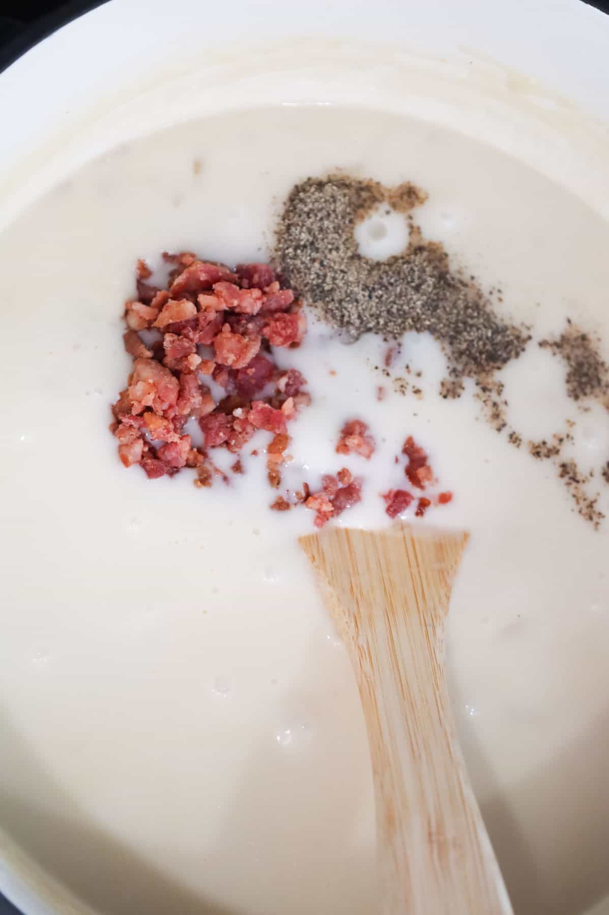 crumbled bacon, salt and pepper added to creamy potato soup