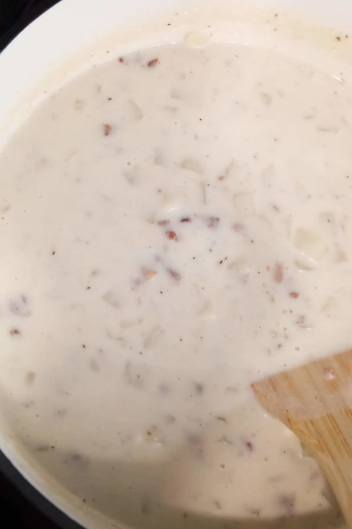 sour cream being stirred into potato soup