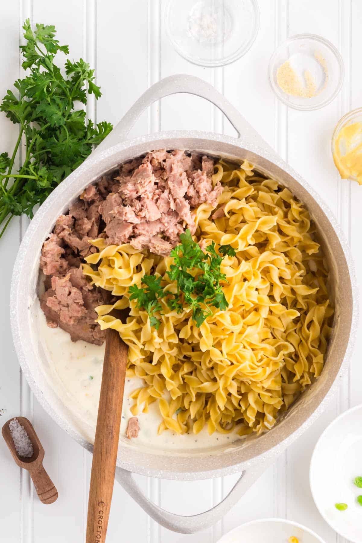 chopped parsley, cooked egg noodles and canned tuna added to pot with creamy sauce mixture