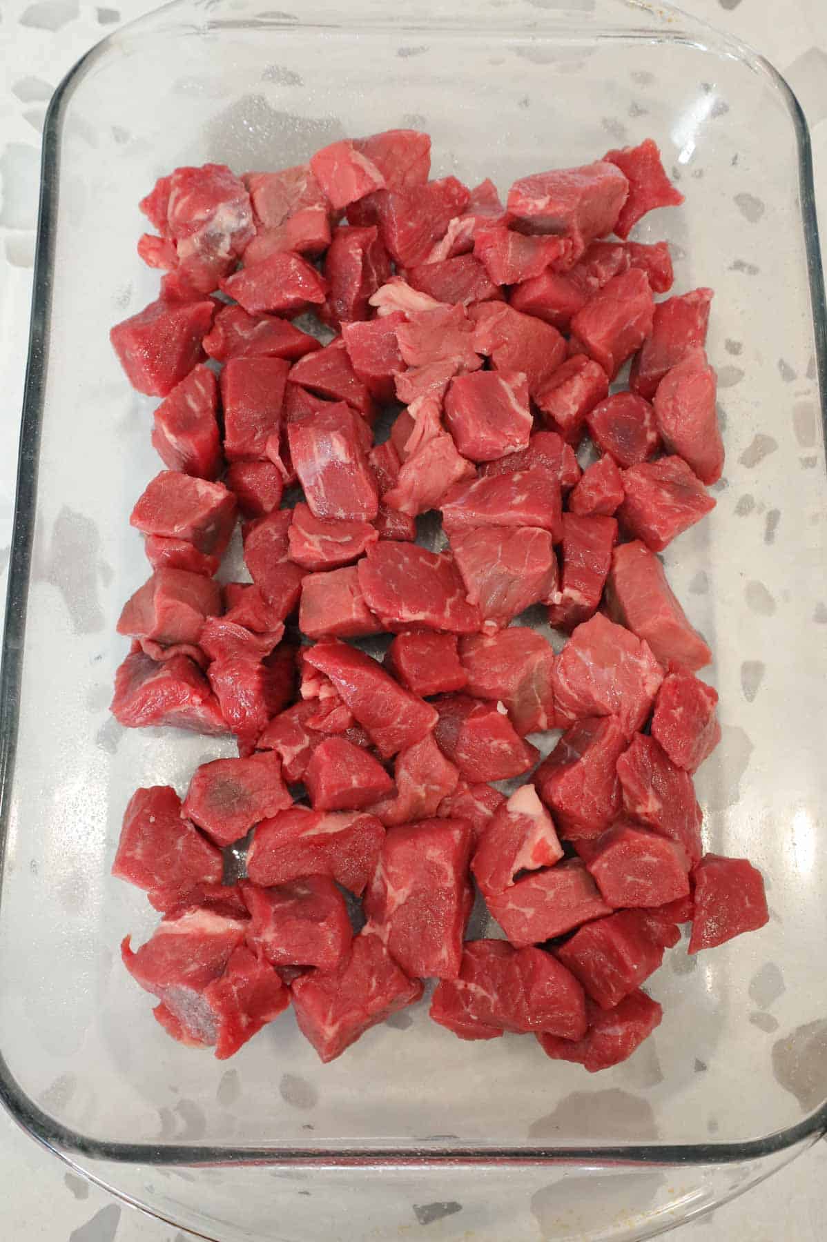cubed stewing beef in a baking dish