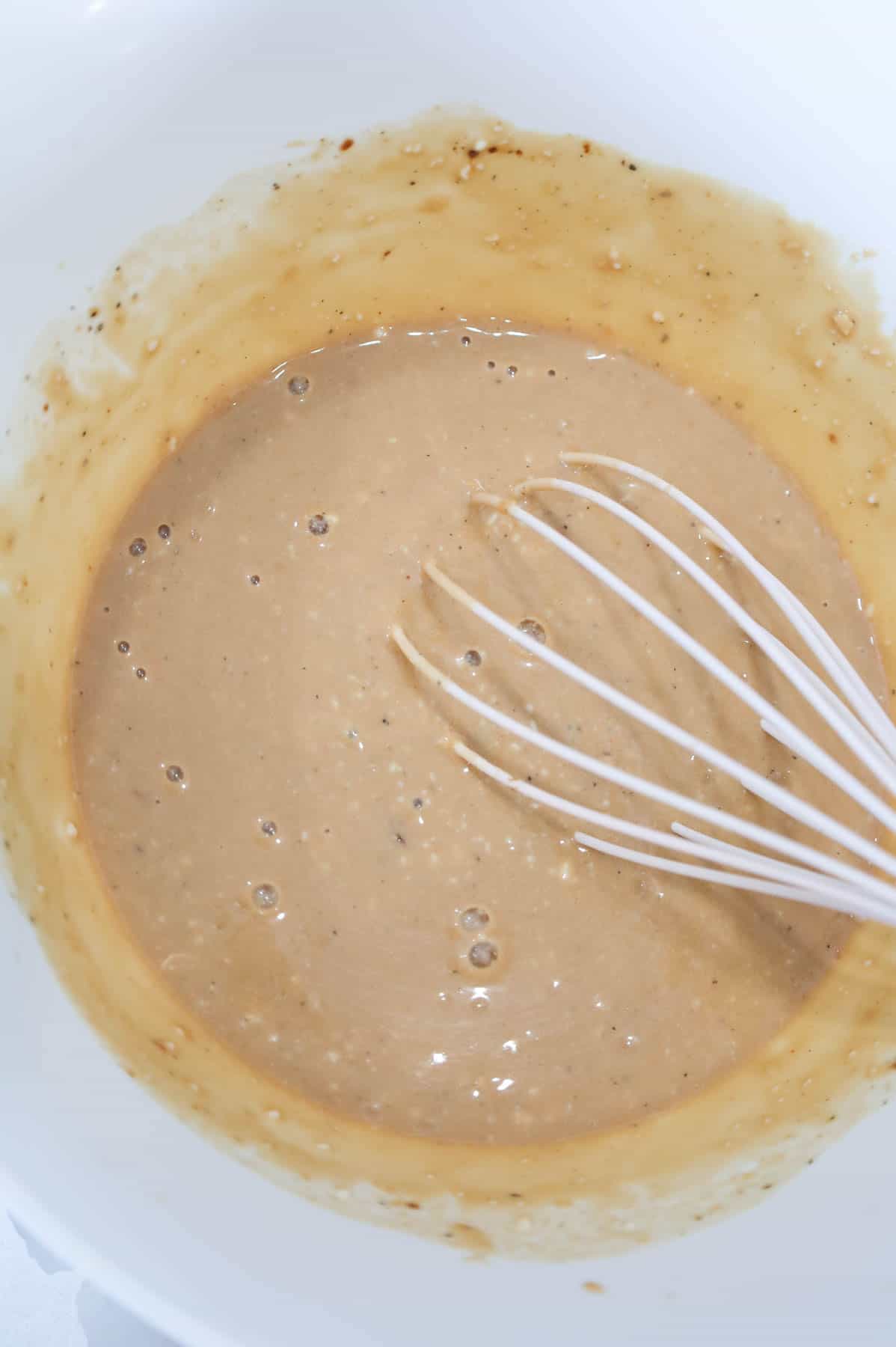 whisking soup and gravy mixture in a mixing bowl
