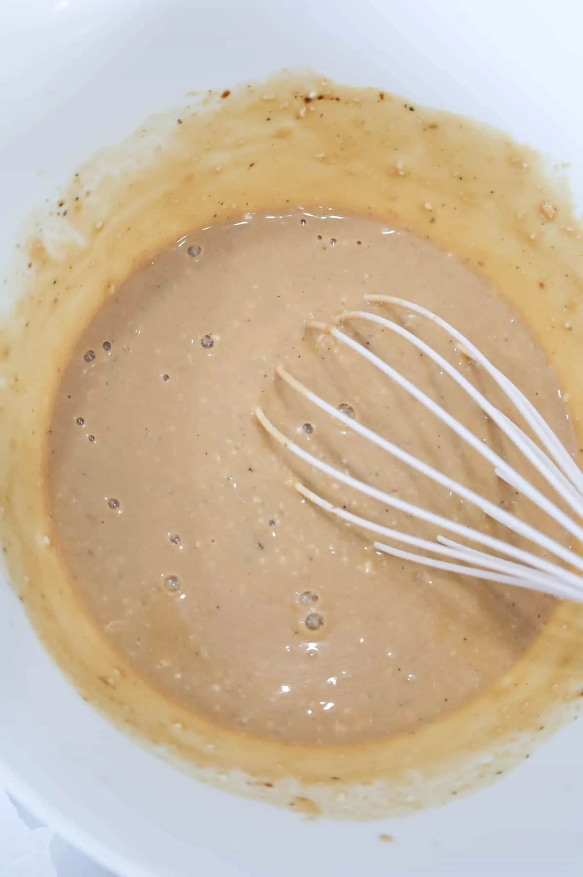 whisking soup and gravy mixture in a mixing bowl