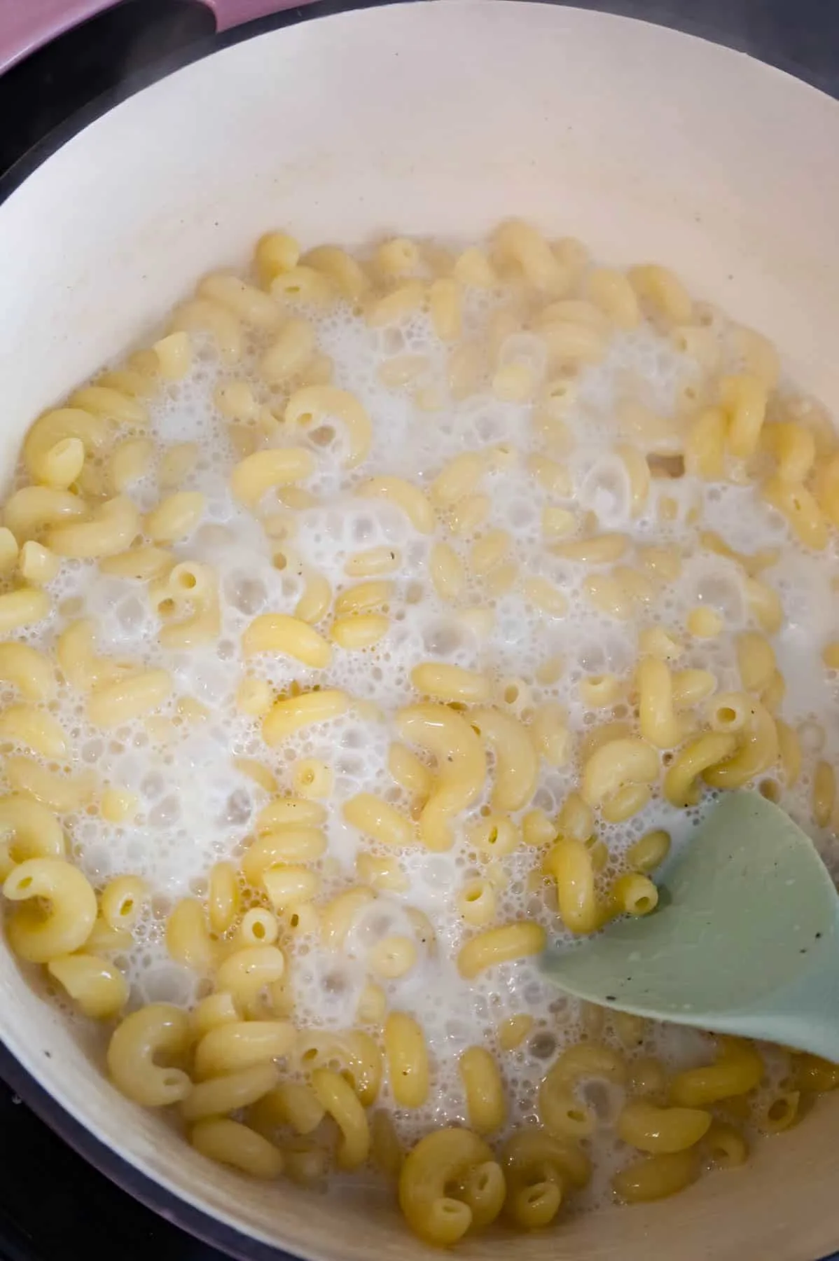 cooked cavatappi noodles in milk in a pot
