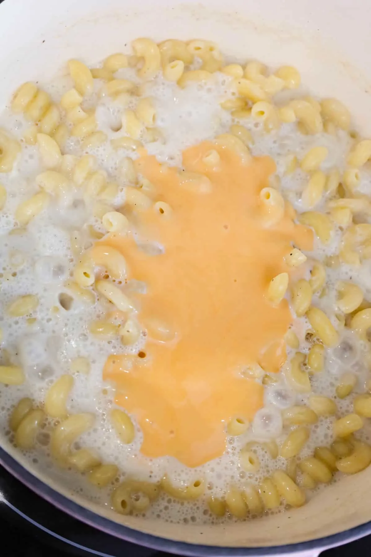 cheddar soup added to pot with cooked cavatappi noodles