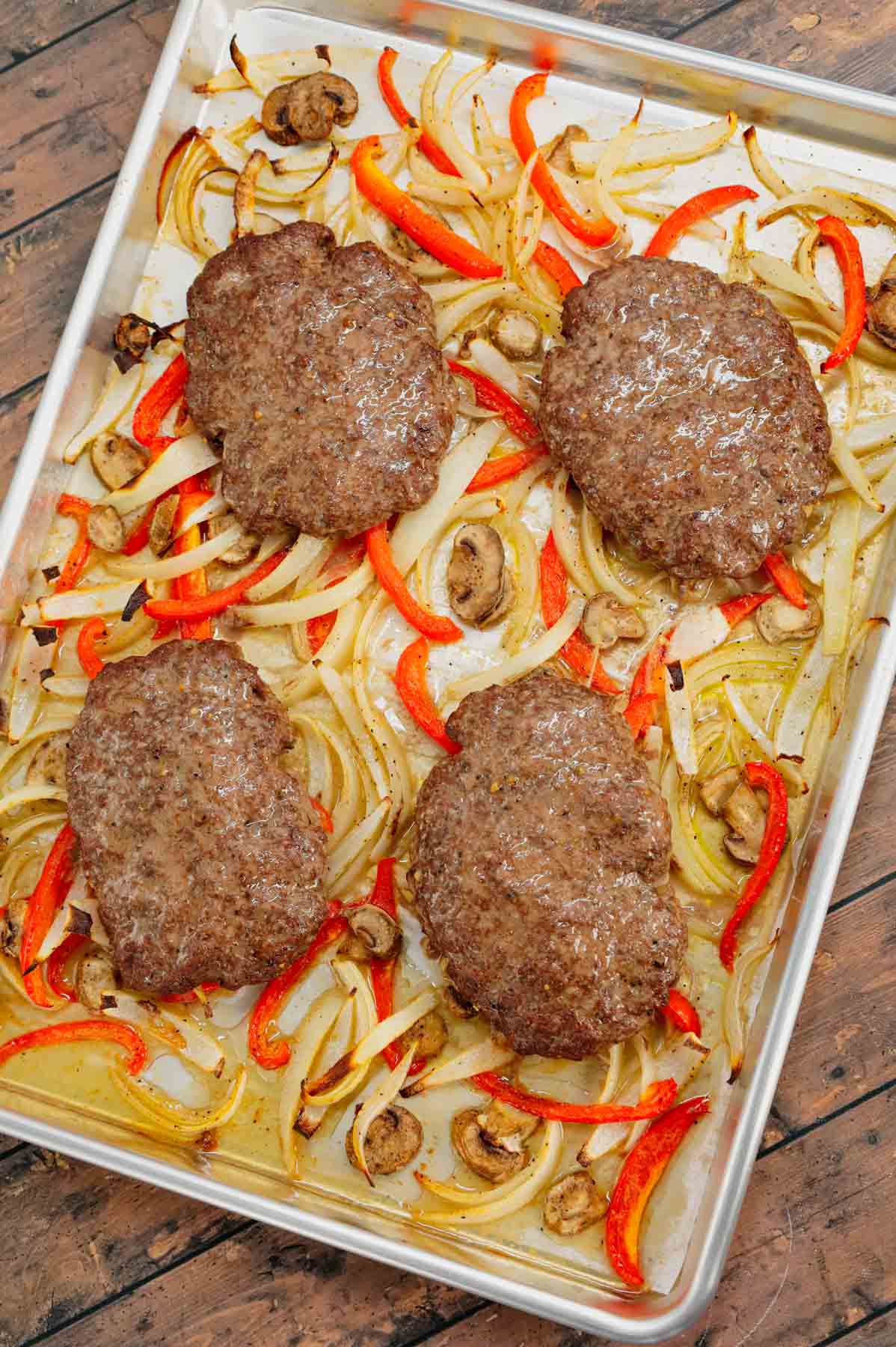 Oven Baked Hamburger Steaks are an easy sheet pan dinner recipe with seasoned ground beef patties cooked along with sliced onions, red bell peppers and mushrooms.