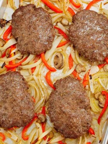 Oven Baked Hamburger Steaks are an easy sheet pan dinner recipe with seasoned ground beef patties cooked along with sliced onions, red bell peppers and mushrooms.