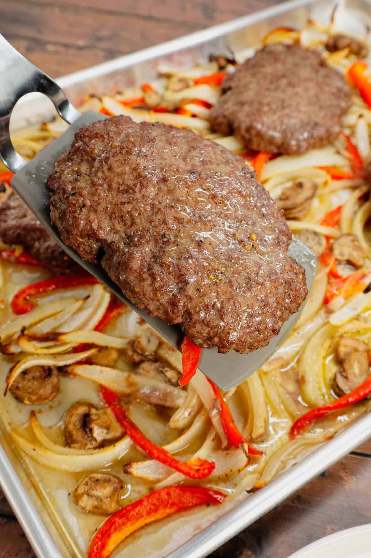 Oven Baked Hamburger Steaks are an easy sheet pan dinner recipe with seasoned ground beef patties cooked along with sliced onions, red bell peppers and mushrooms.