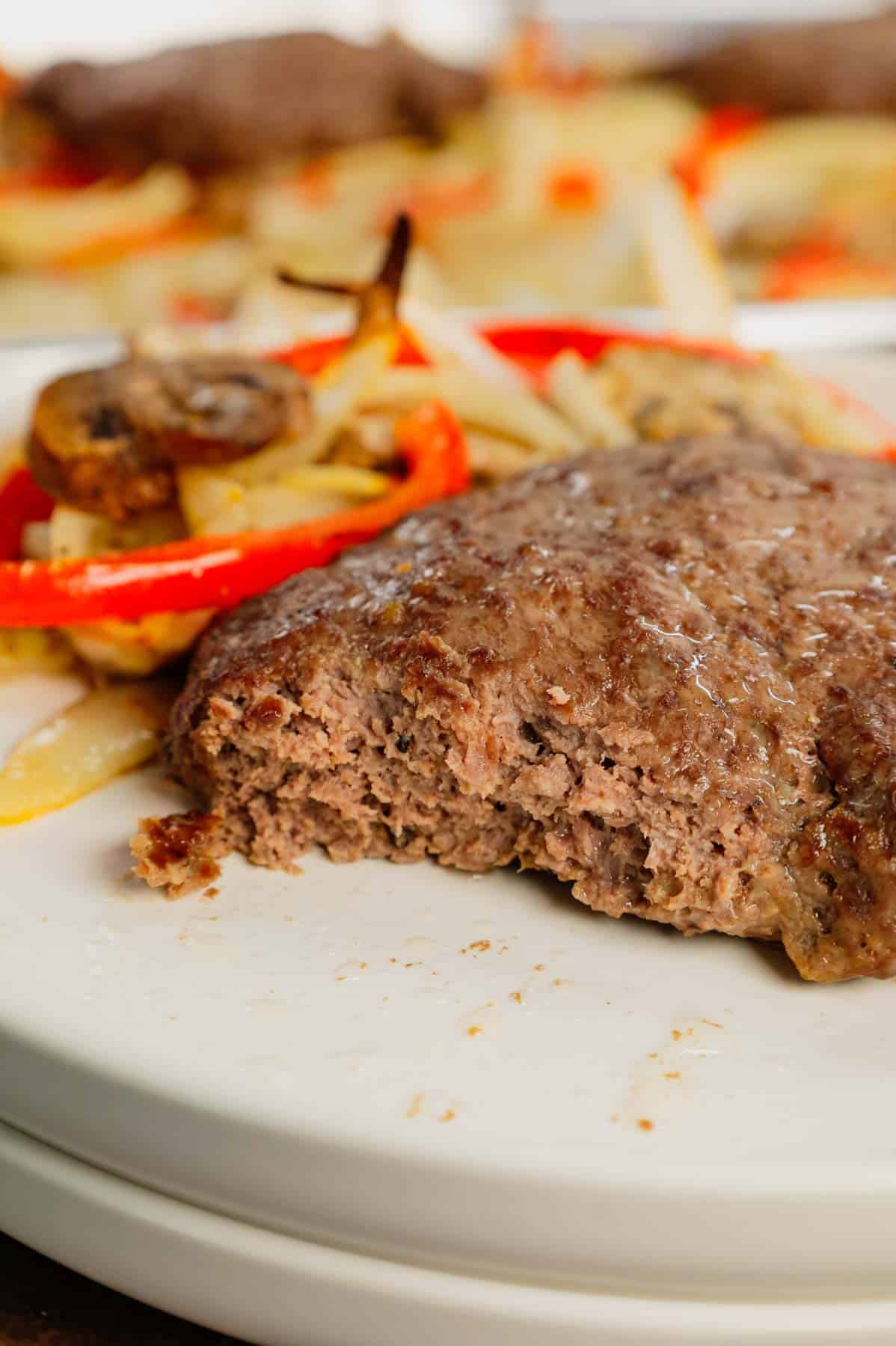 Oven Baked Hamburger Steaks are an easy sheet pan dinner recipe with seasoned ground beef patties cooked along with sliced onions, red bell peppers and mushrooms.