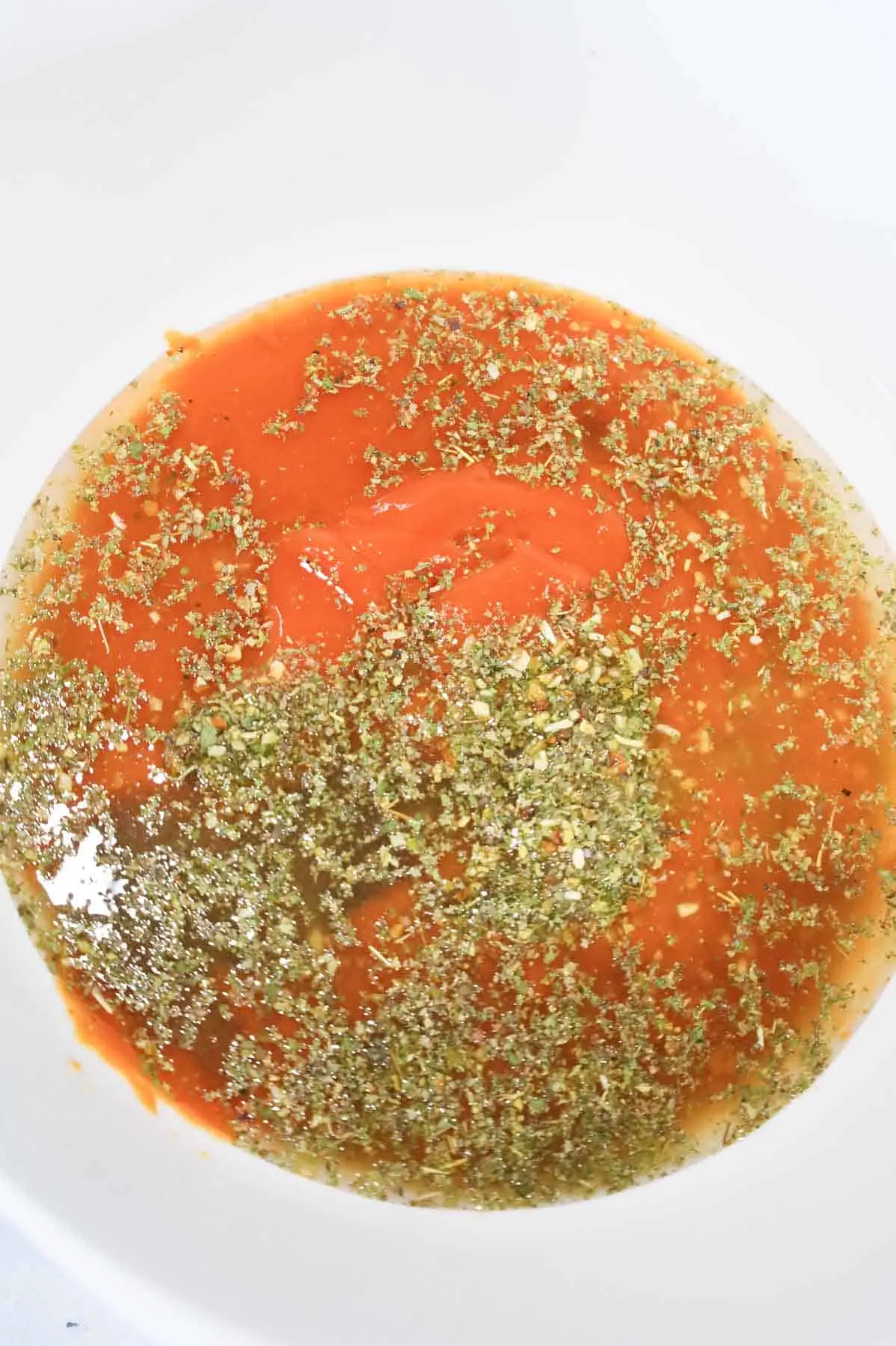water, Worcestershire sauce, Italian seasoning and condensed tomato soup in a mixing bowl