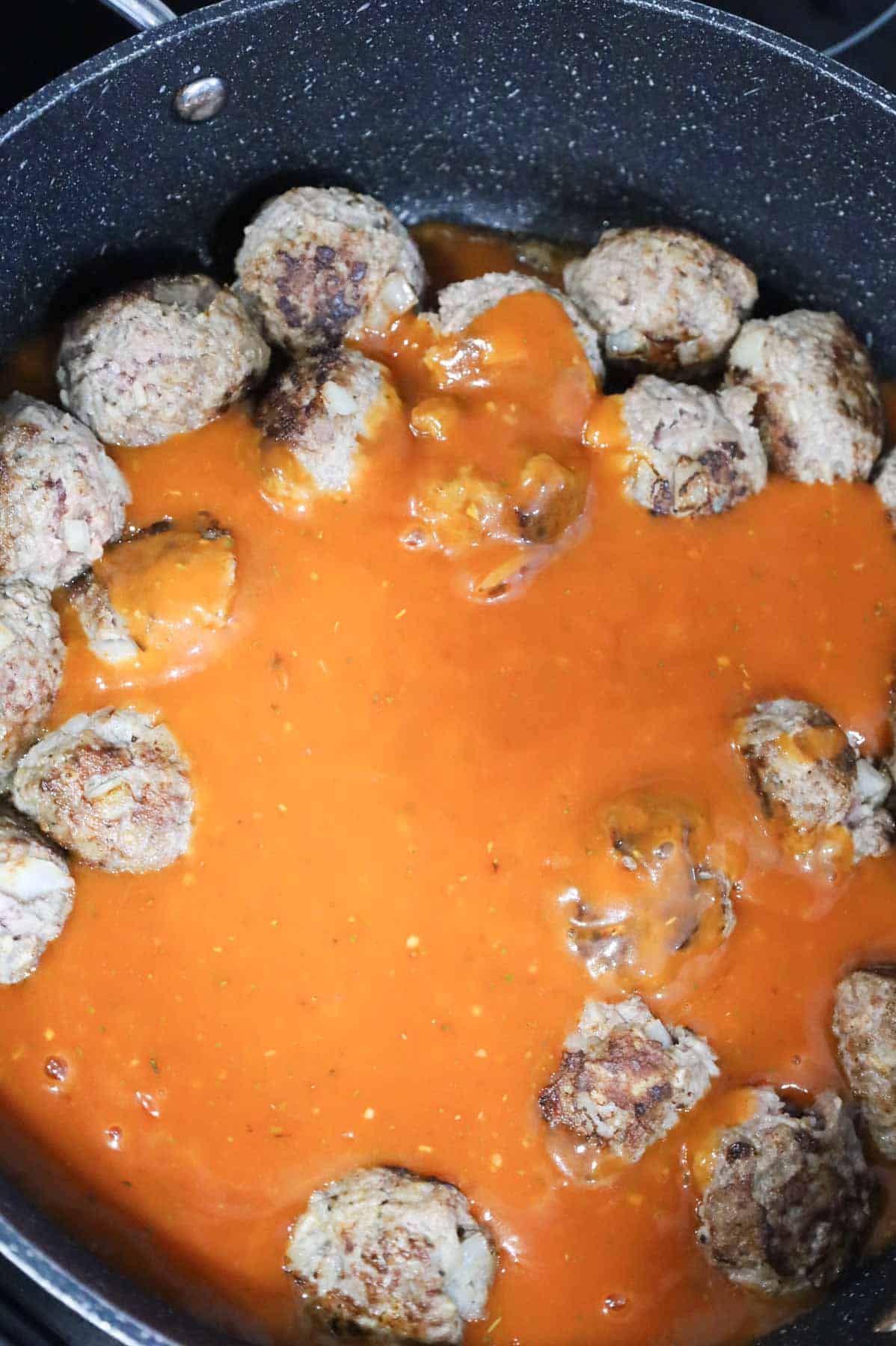tomato soup mixture added to skillet with browned meatballs