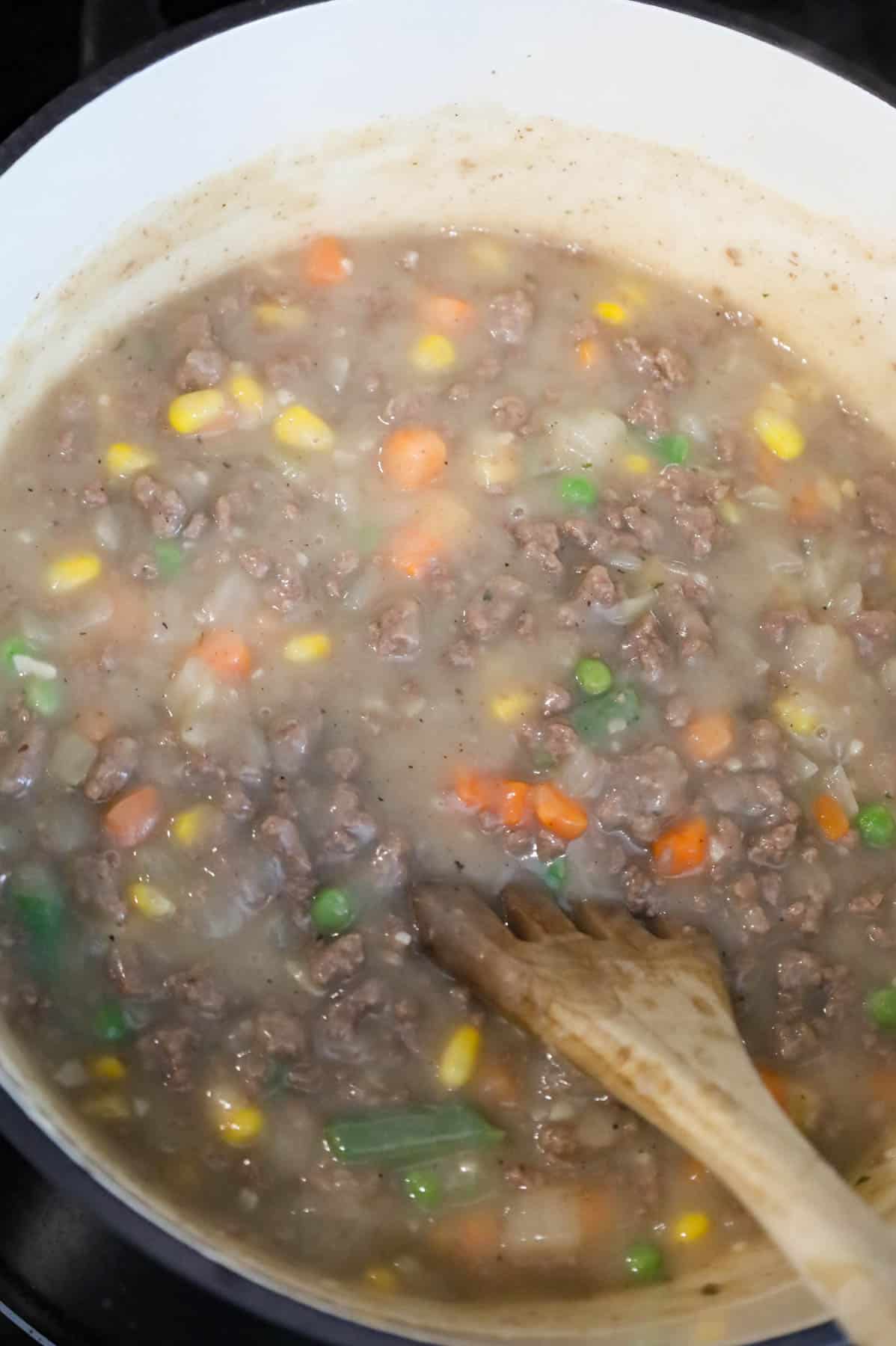 stirring frozen veggies into shepherd's pie soup