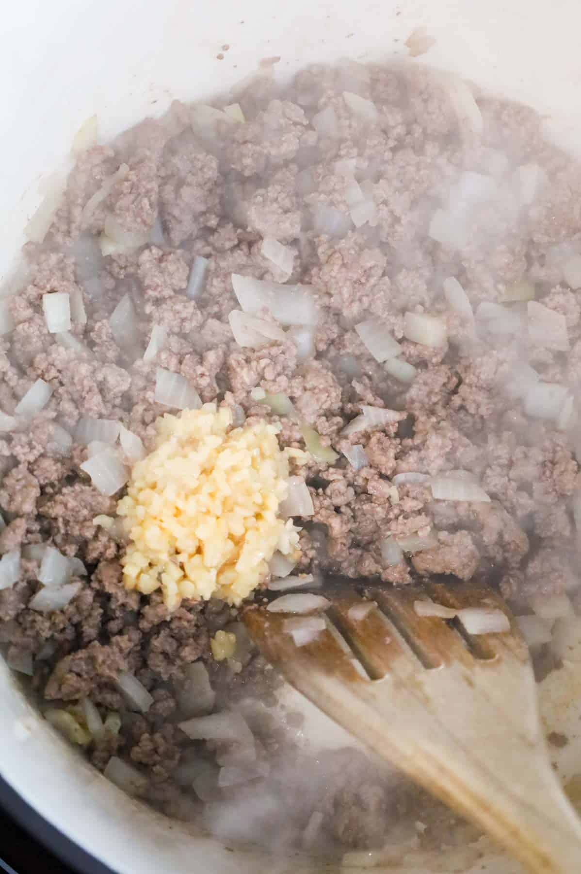 minced garlic added to pot with cooked ground beef and diced onions