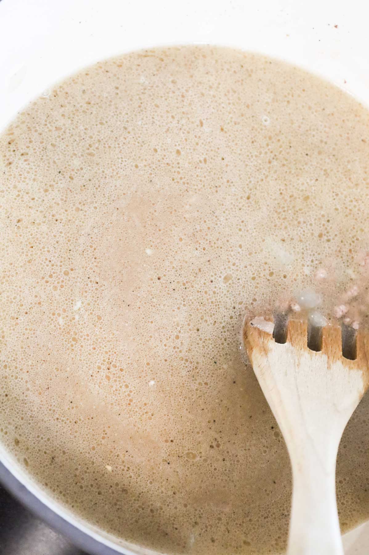 stirring broth, seasonings and ground beef together in a Dutch oven