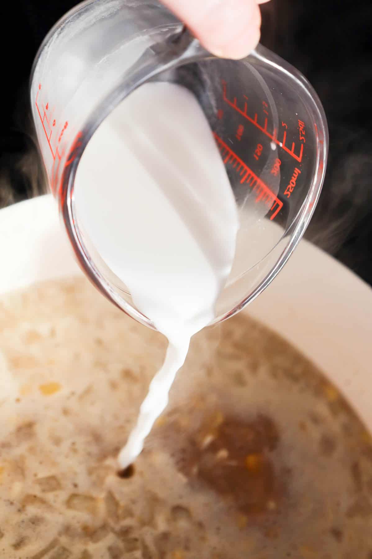 cornstarch slurry being poured into sweet corn soup