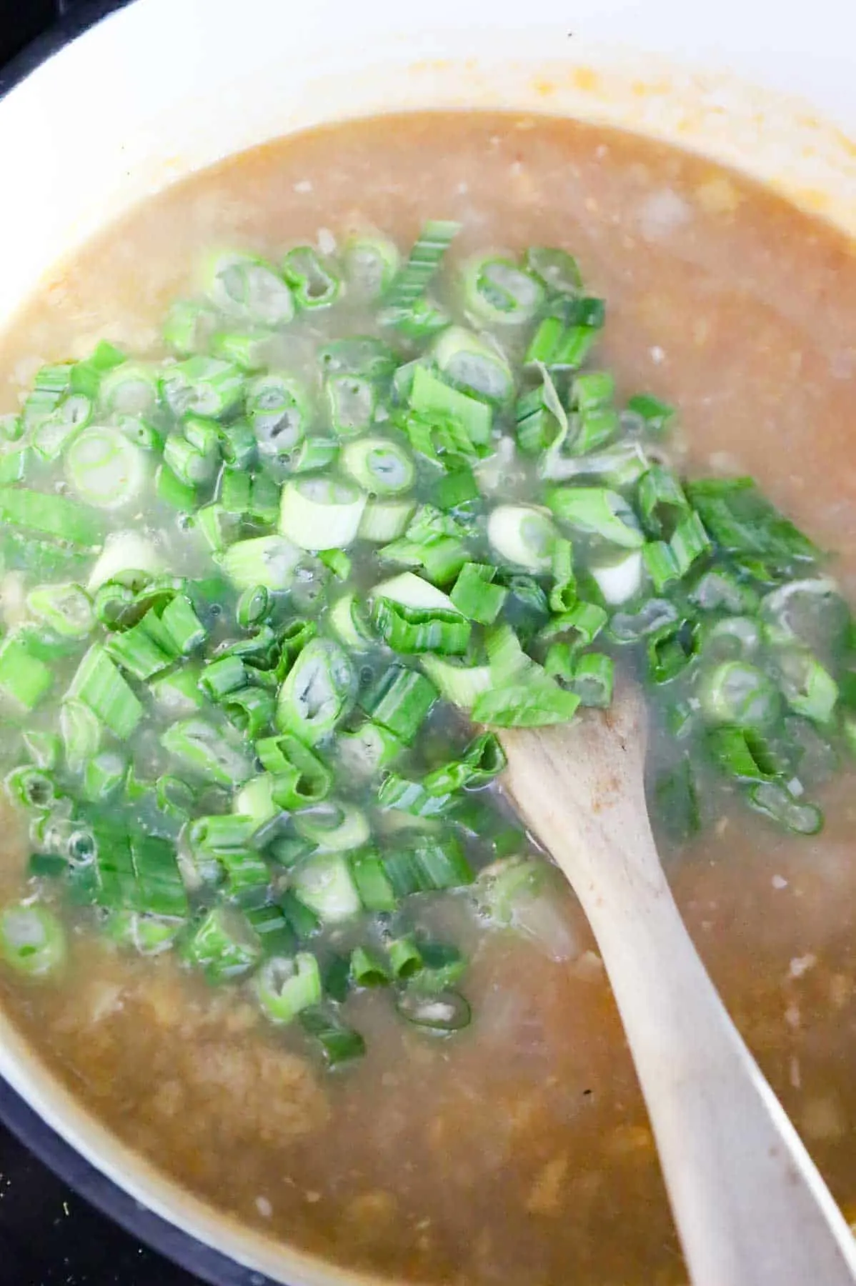 chopped green onions added to sweet corn soup