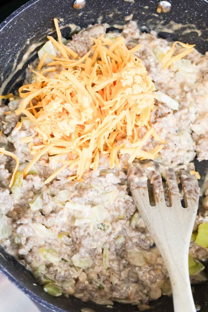 shredded cheese added to skillet with creamy ground beef mixture
