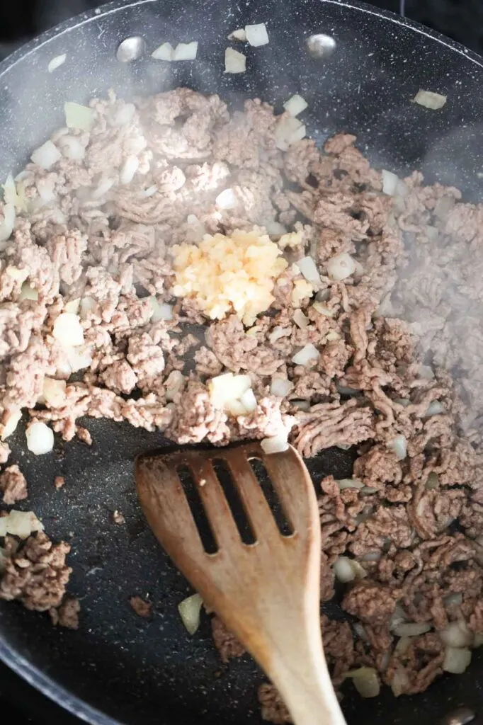 minced garlic added to skillet with cooked ground beef