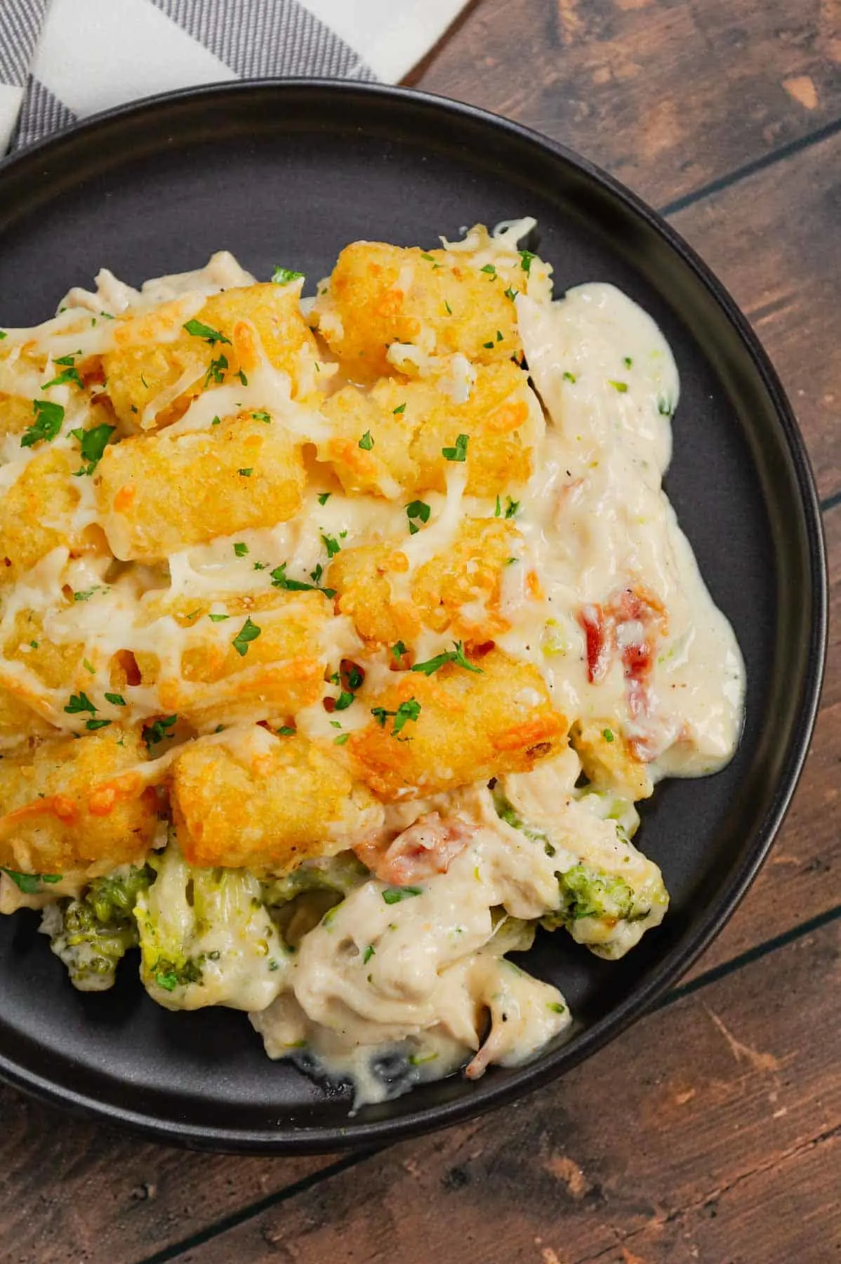 Chicken Alfredo Tater Tot Casserole is a hearty dish loaded with shredded rotisserie chicken, chopped bacon, broccoli, Alfredo sauce, parmesan and mozzarella topped with tater tots baked until golden brown and crispy.