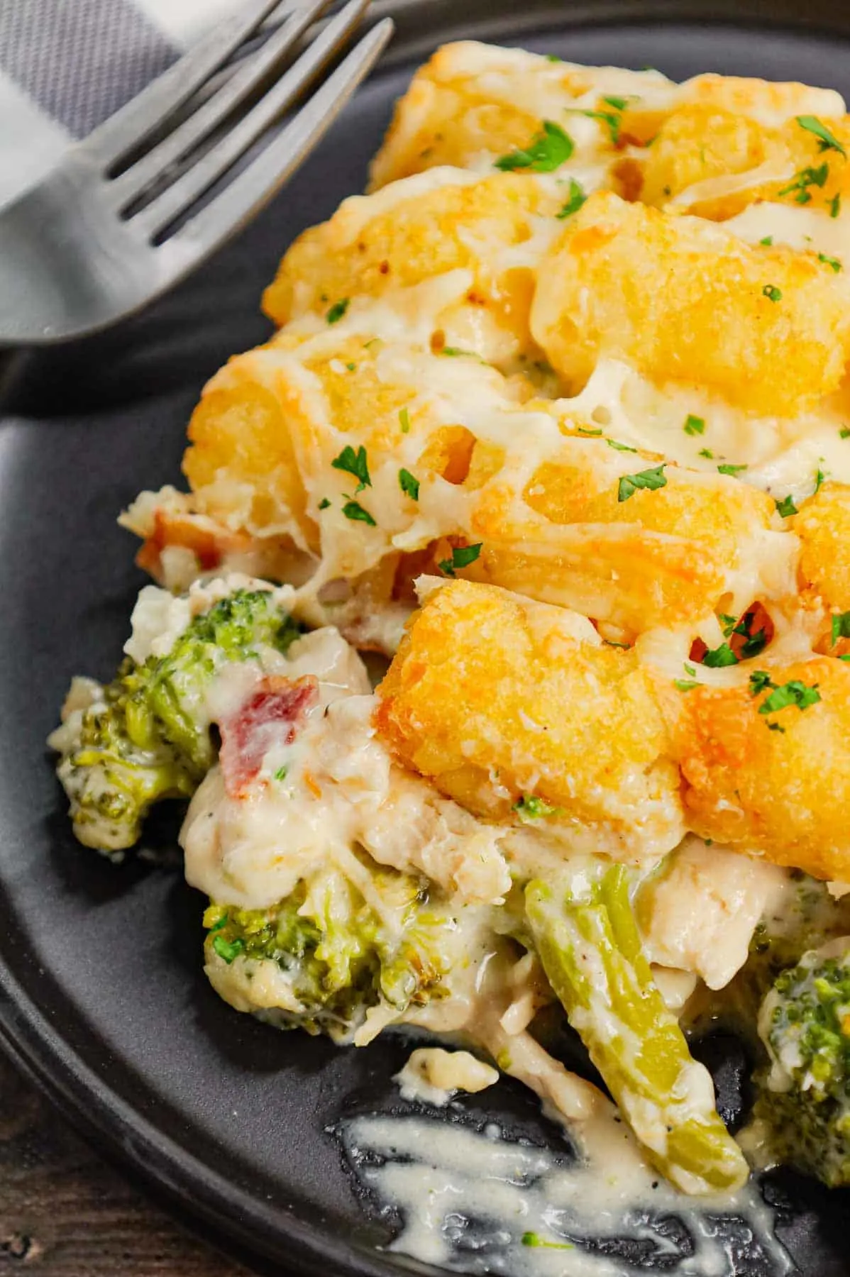 Chicken Alfredo Tater Tot Casserole is a hearty dish loaded with shredded rotisserie chicken, chopped bacon, broccoli, Alfredo sauce, parmesan and mozzarella topped with tater tots baked until golden brown and crispy.