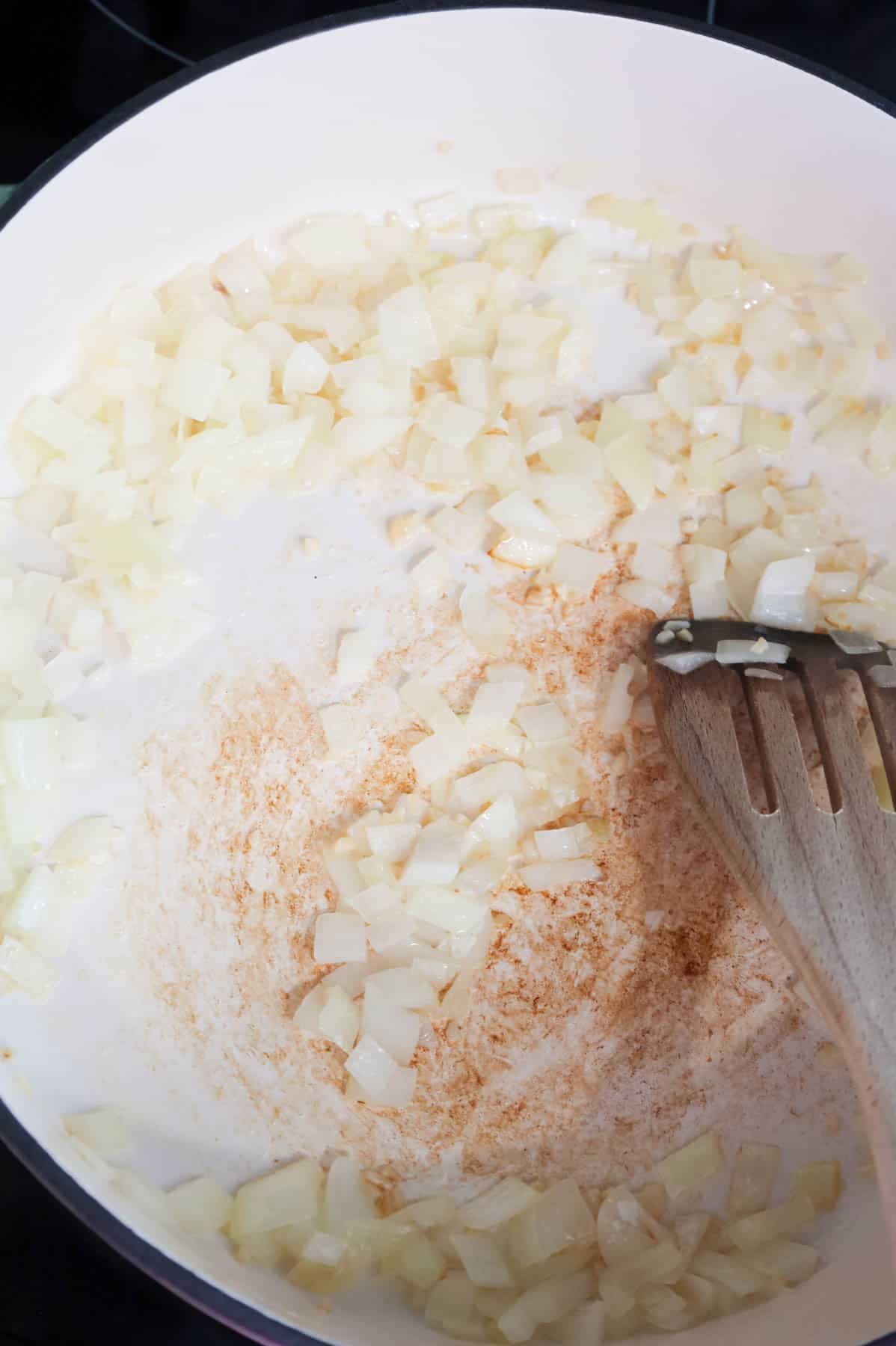 stirring minced garlic and diced onions in a skillet