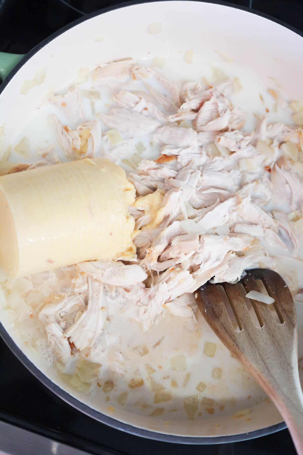 condensed cream of chicken soup and milk added to skillet with shredded chicken